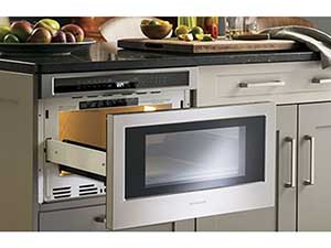 A microwave drawer, in the island at counter height, opens and closes by touch.